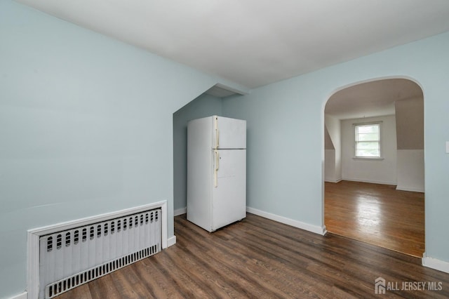 4 Ashwood Pl, North Brunswick, NJ 08902 - empty room with radiator heating unit, arched walkways, wood finished floors, and baseboards