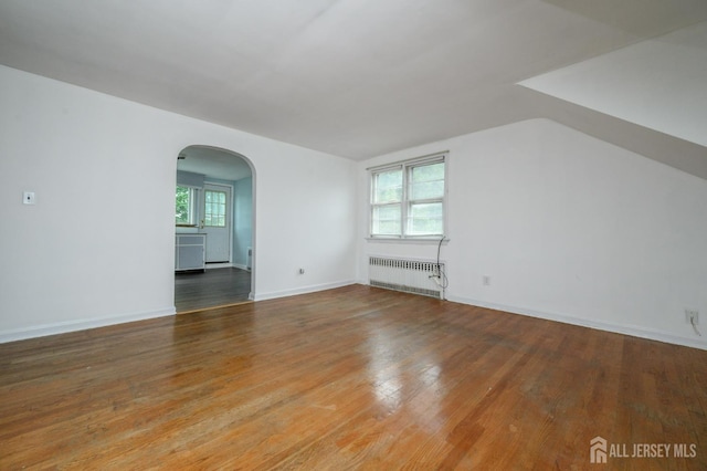 4 Ashwood Pl, North Brunswick, NJ 08902 - unfurnished room featuring radiator heating unit, arched walkways, wood finished floors, and baseboards