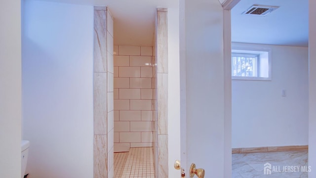 full bathroom with toilet, visible vents, and tiled shower