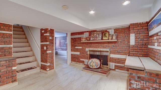 living area featuring visible vents, brick wall, a brick fireplace, stairway, and recessed lighting