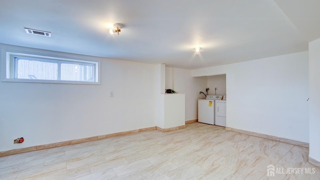 unfurnished room featuring washing machine and dryer, visible vents, and baseboards