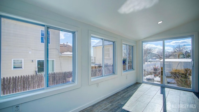 sunroom / solarium featuring plenty of natural light and vaulted ceiling