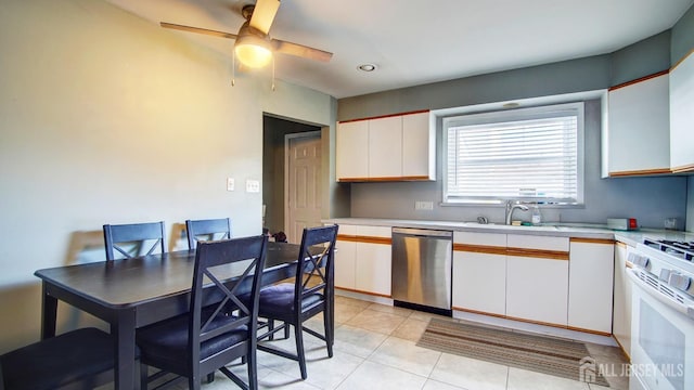 kitchen with stainless steel dishwasher, white range with gas cooktop, light countertops, and white cabinetry