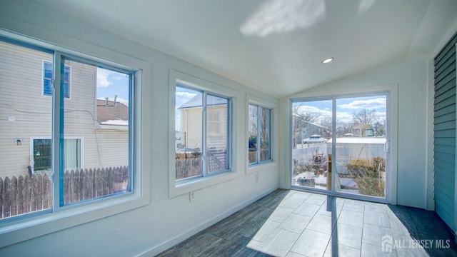 unfurnished sunroom featuring plenty of natural light and vaulted ceiling