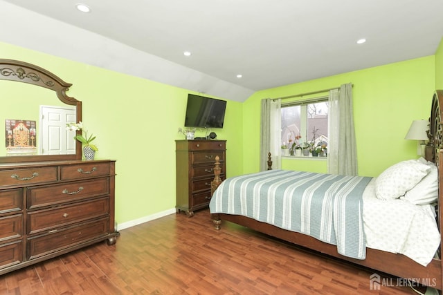 bedroom with wood finished floors, vaulted ceiling, baseboards, and recessed lighting