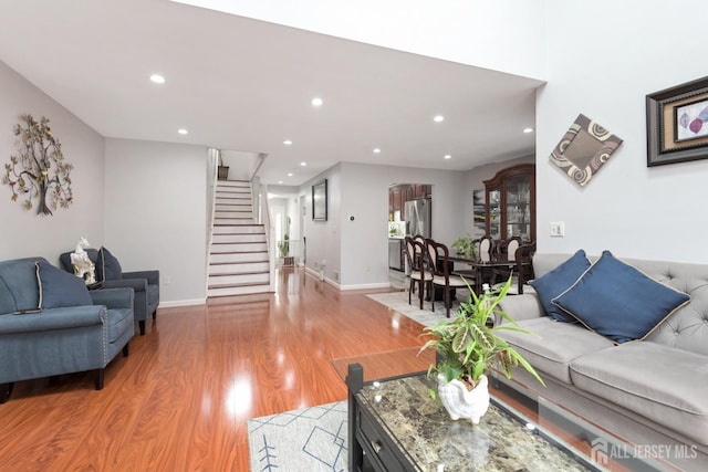 living area featuring stairway, light wood-type flooring, recessed lighting, and baseboards