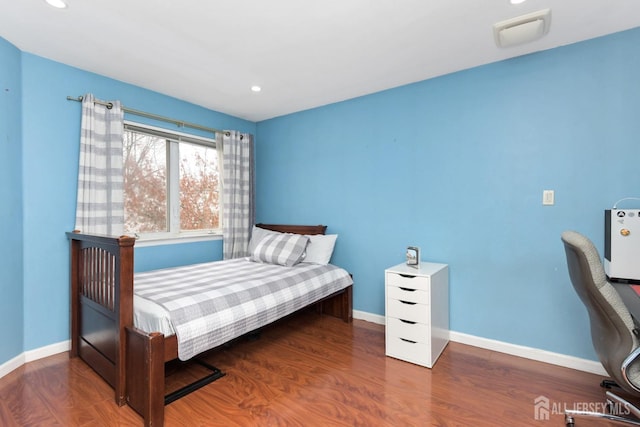 bedroom featuring wood finished floors, baseboards, and recessed lighting