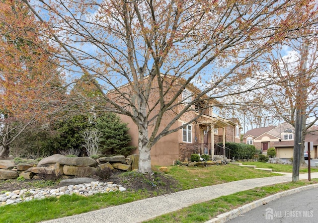 view of front facade featuring a front yard, stucco siding, and a residential view