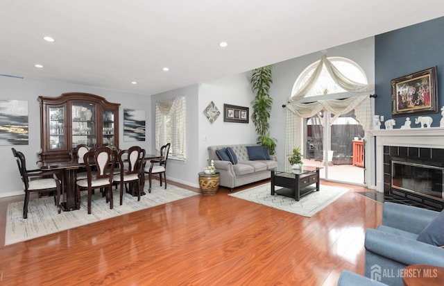 living room featuring wood finished floors, recessed lighting, a fireplace, and baseboards