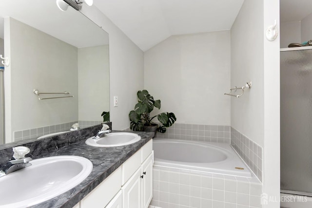full bathroom with a garden tub, double vanity, vaulted ceiling, and a shower with shower door