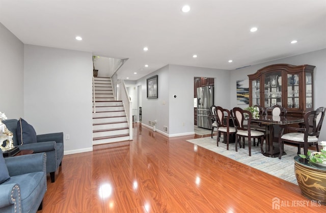 living room with wood finished floors, stairs, baseboards, and recessed lighting