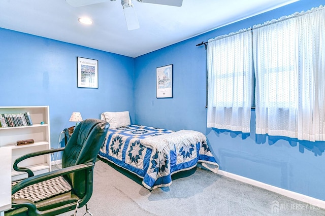 carpeted bedroom featuring baseboards and a ceiling fan