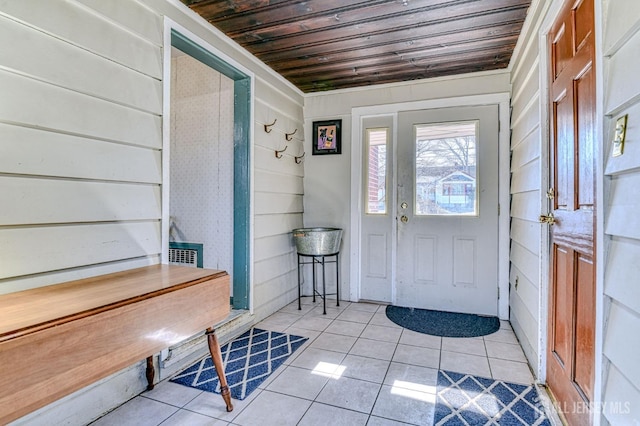 foyer with light tile patterned floors, wooden walls, and wood ceiling