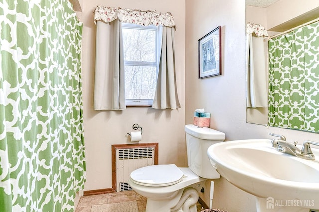 full bath featuring toilet, a sink, radiator heating unit, a shower with shower curtain, and baseboards