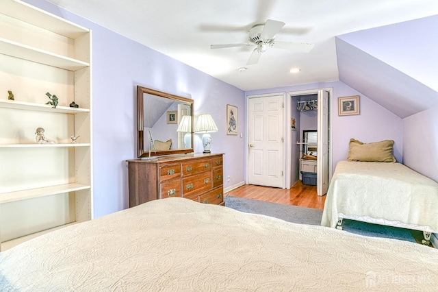 bedroom featuring a ceiling fan, vaulted ceiling, and wood finished floors