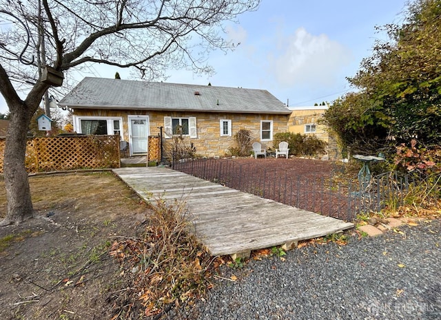 back of property featuring stone siding