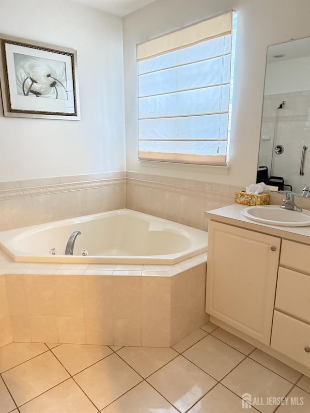 full bathroom featuring a bath, walk in shower, vanity, and tile patterned floors