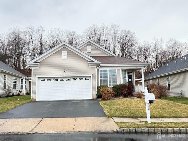 ranch-style home with driveway, roof with shingles, a front yard, and a garage