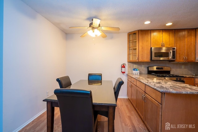 dining space featuring baseboards, recessed lighting, a ceiling fan, and light wood-style floors