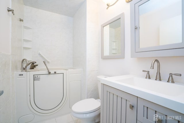 bathroom with toilet, tile walls, and vanity