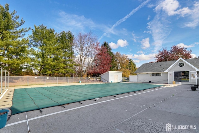 view of pool featuring a fenced in pool, an outbuilding, fence, and a patio