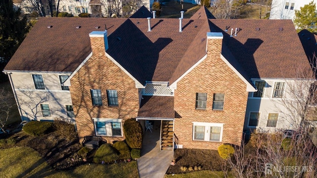 view of front of house featuring brick siding and a chimney