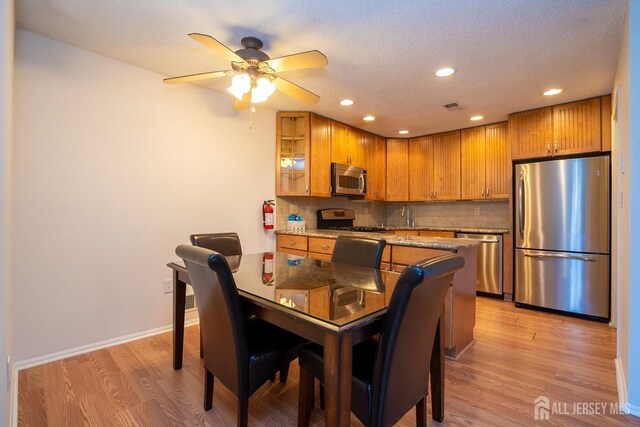 dining room with a textured ceiling, recessed lighting, visible vents, baseboards, and light wood-style floors