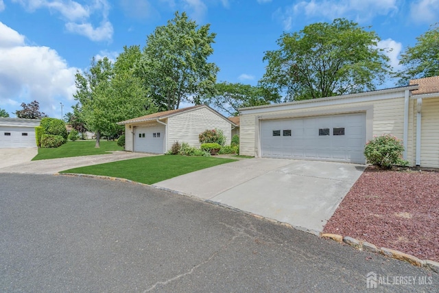 view of front facade with an outbuilding, a front lawn, and a garage