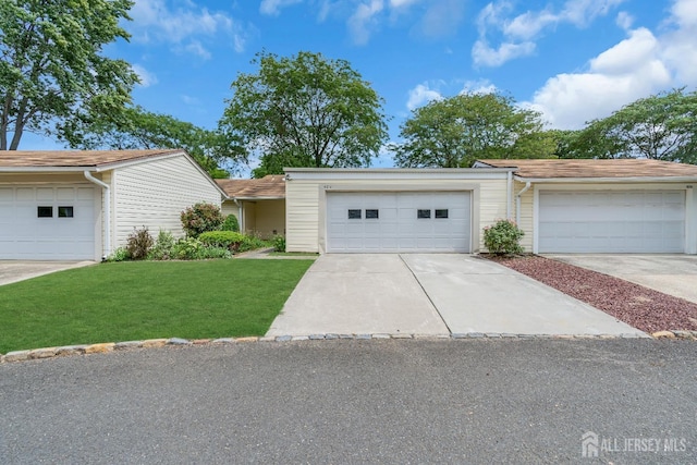 ranch-style house with a garage and a front lawn