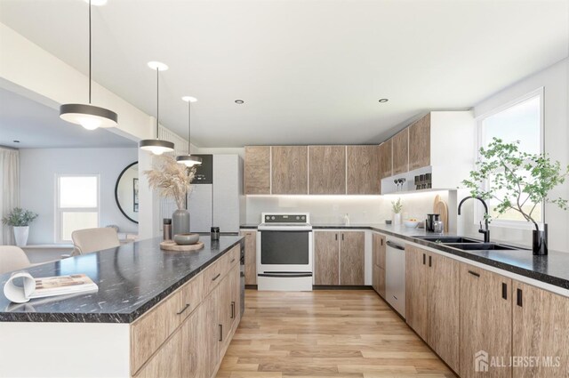 kitchen with a sink, light brown cabinets, electric stove, light wood-style floors, and stainless steel dishwasher