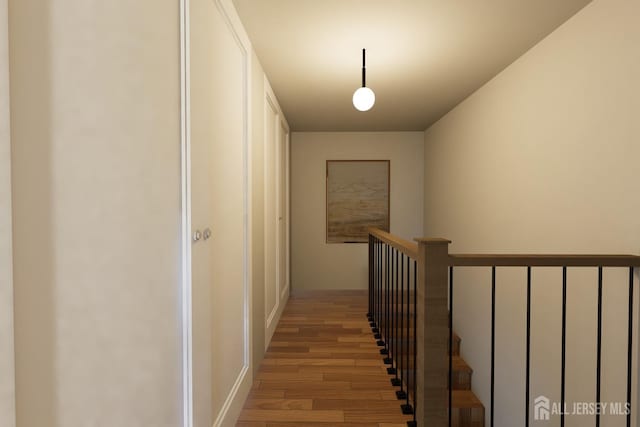 corridor with an upstairs landing and light wood-type flooring