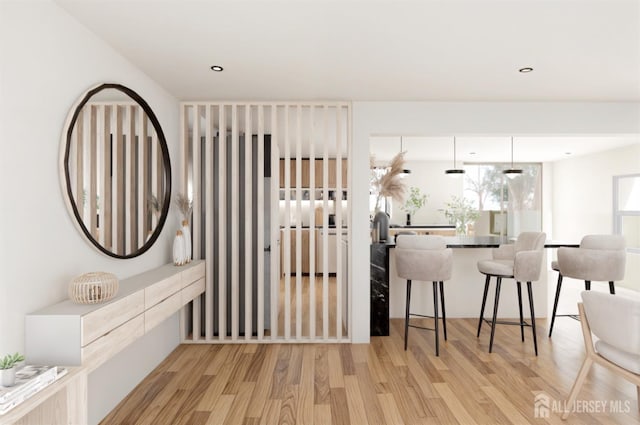 kitchen featuring a kitchen breakfast bar, recessed lighting, and light wood-style floors