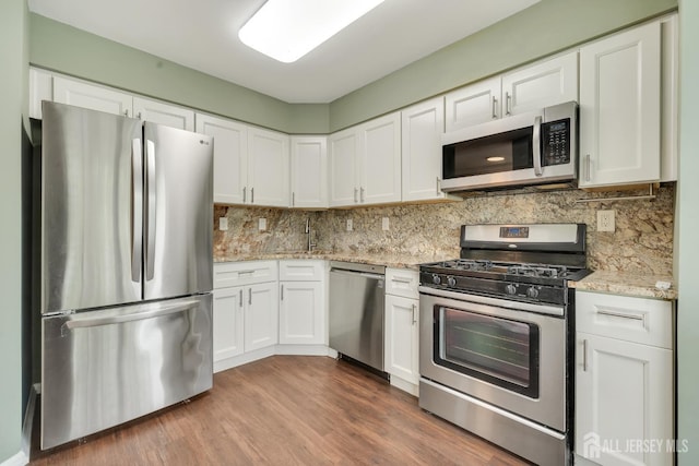 26 Desoto Dr, Franklin Twsp, NJ 08823 - kitchen with appliances with stainless steel finishes, white cabinets, tasteful backsplash, and wood finished floors