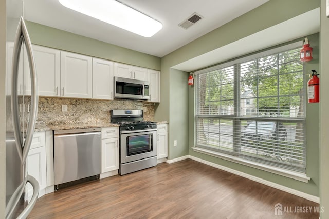 26 Desoto Dr, Franklin Twsp, NJ 08823 - kitchen with appliances with stainless steel finishes, decorative backsplash, white cabinets, dark wood-style floors, and light stone countertops