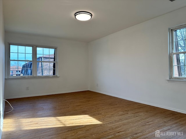 empty room featuring baseboards and wood finished floors