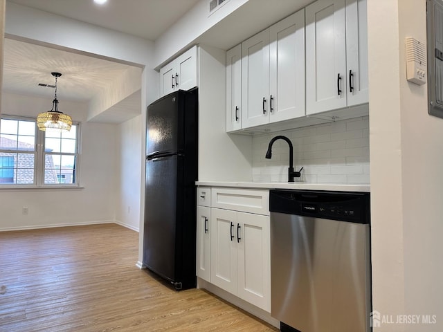 kitchen with light wood-style flooring, stainless steel dishwasher, freestanding refrigerator, white cabinets, and light countertops