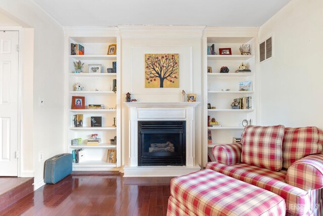 135 Archery Ct, Old Bridge, NJ 08857 - living room featuring built in shelves, a fireplace with raised hearth, wood finished floors, and visible vents
