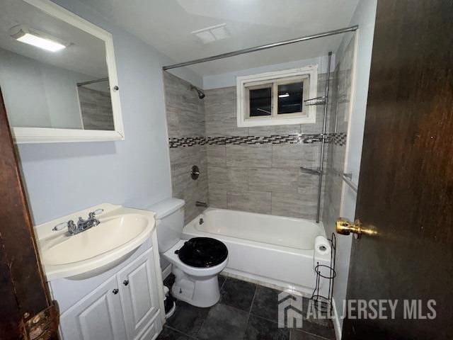 bathroom with toilet, vanity, washtub / shower combination, and tile patterned floors