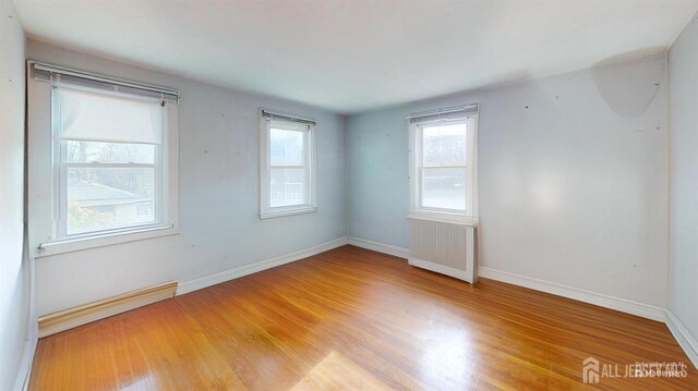 spare room with light hardwood / wood-style flooring and radiator heating unit