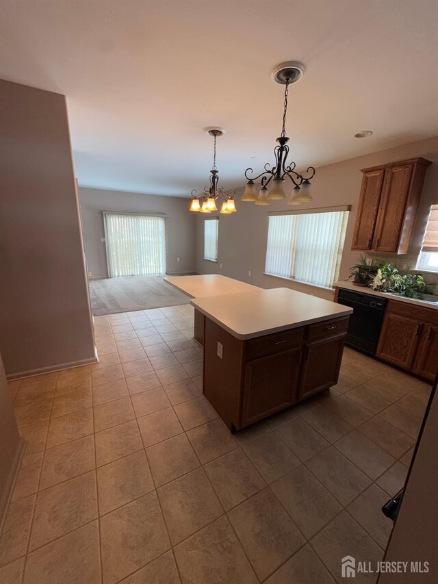 kitchen featuring pendant lighting, tile patterned floors, a center island, and black dishwasher