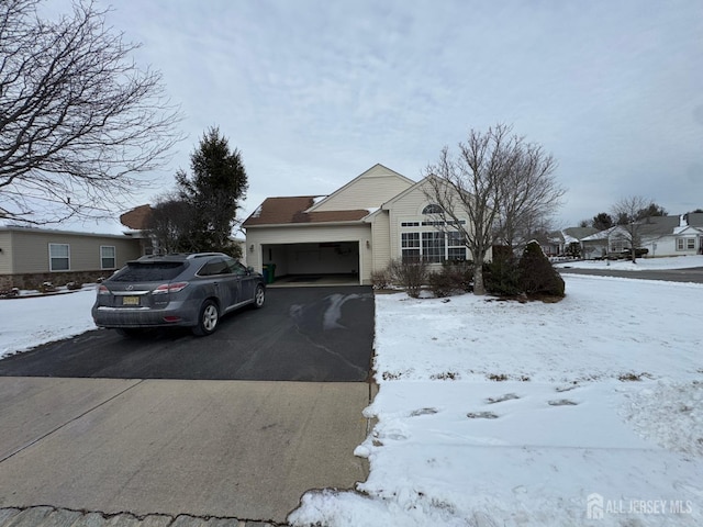 ranch-style house with aphalt driveway and an attached garage