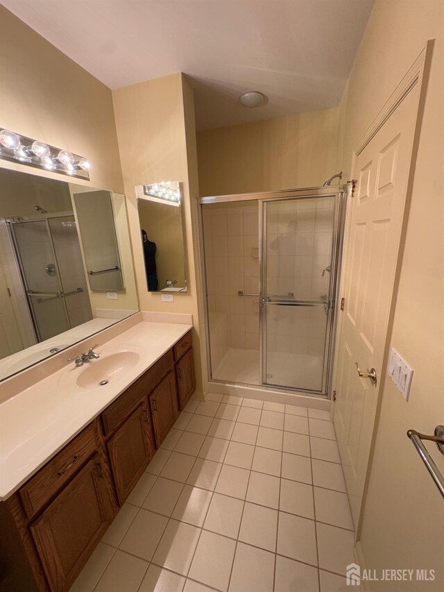 bathroom with vanity, an enclosed shower, and tile patterned flooring