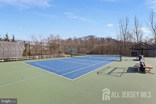 view of tennis court featuring fence