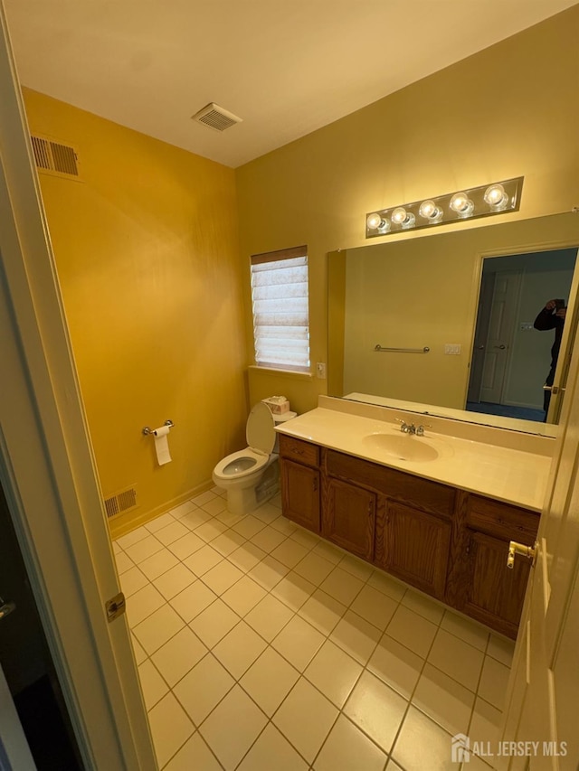 bathroom with tile patterned flooring, vanity, and toilet