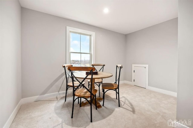 carpeted dining space featuring baseboards