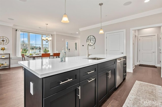 kitchen featuring a sink, light countertops, an island with sink, and a notable chandelier