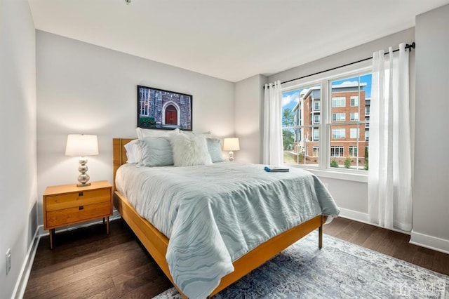 bedroom with dark wood-type flooring and baseboards