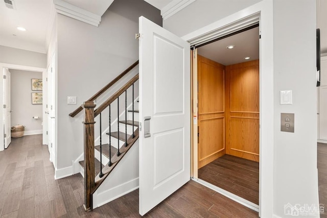 staircase featuring elevator, visible vents, recessed lighting, and wood finished floors