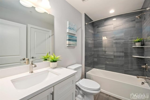 bathroom with toilet, shower / bathing tub combination, recessed lighting, vanity, and wood finished floors