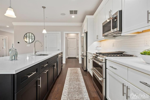 kitchen with visible vents, white cabinets, a sink, high quality appliances, and crown molding